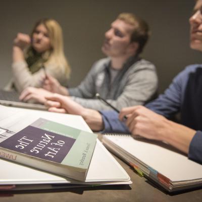 A picture of three students studying and the "The Nature of Art" on the table